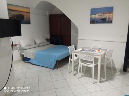 una camera con letto e tavolo con sedie di Al Vicolo a Gaeta