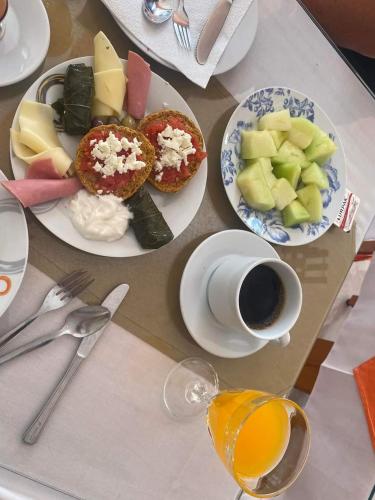 a table with plates of food and a cup of coffee at Kissandros Hotel in Agia Galini
