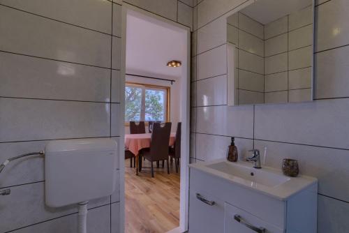 a bathroom with a sink and a mirror and a table at Vila Podkalac in Žrnovo