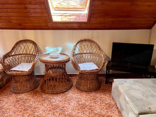 three wicker chairs and a table in a living room at Orosz Apartmanház Gyula in Gyula