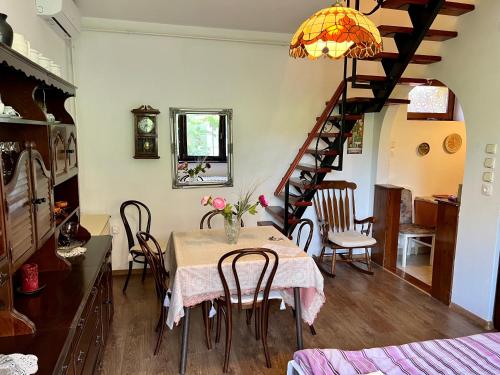 a dining room with a table and a staircase at Orosz Apartmanház Gyula in Gyula