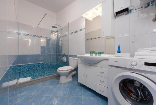 een badkamer met een wastafel en een wasmachine bij Villa bazen,jacuzzy in Sukošan