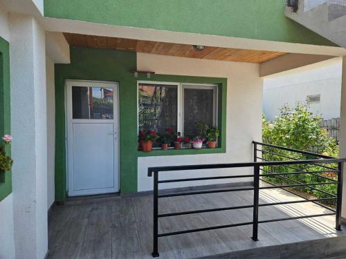 una camera con porta e balcone con piante di Muzicii 11 - Cozy Seaside Apartments a Năvodari