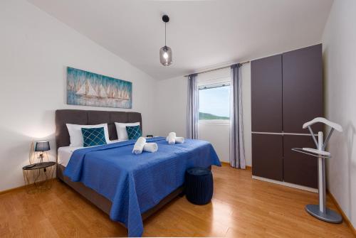 Villa bazen,jacuzzy في سوكوشان: غرفة نوم بسرير ازرق مع بطانية زرقاء