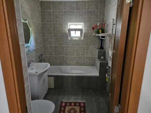 a bathroom with a tub and a toilet and a sink at Muzicii 11 - Cozy Seaside Apartments in Năvodari