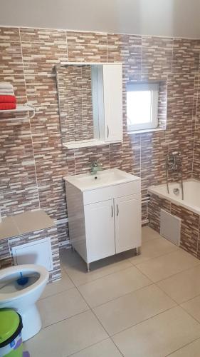 a bathroom with a sink and a toilet and a tub at Muzicii 11 - Cozy Seaside Apartments in Năvodari