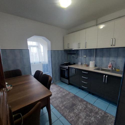 eine Küche mit einem Waschbecken und einem Tisch darin in der Unterkunft Apartament Sara in Bîrlad