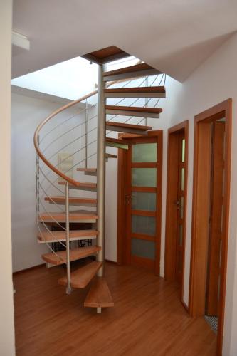 a metal spiral staircase in a room with wooden floors at Large house with parking, 30 min to Prague center in Úvaly