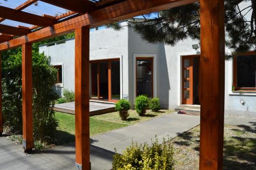 a white house with a wooden pergola at Large house with parking, 30 min to Prague center in Úvaly
