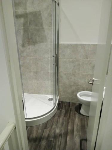 ein Bad mit einer Dusche und einem WC in der Unterkunft Double bed (R2) close to Burnley city centre in Burnley