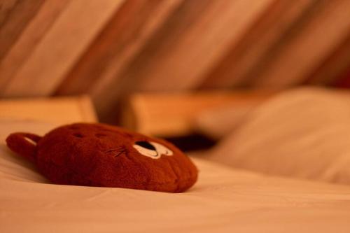 a teddy bear laying on top of a bed at La Reserve in Brugelette