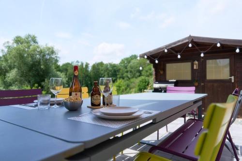 una mesa con dos botellas de vino y copas en La Reserve, en Brugelette