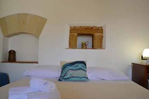 a bedroom with a bed and a mirror on the wall at HOTEL Cala Buguto in Custonaci