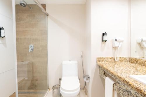 uma casa de banho com um WC, um chuveiro e um lavatório. em Saui­pe Premium Sol All Inclusive na Costa do Sauípe