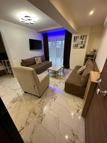 a living room with a couch and a chair at Blue Star #4 in Paralia Katerinis