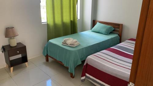 a room with two beds and a night stand with a bed sidx sidx at DEPARTAMENTO A ESTRENAR EN CONDOMINIO NUEVO 2023 zona norte cerca UCEBOL in Santa Cruz de la Sierra