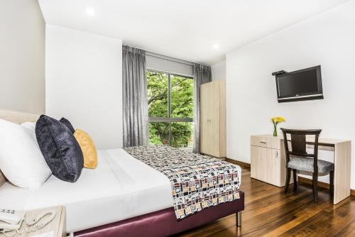 a hotel room with a bed and a window at Hotel Asturias Medellin in Medellín