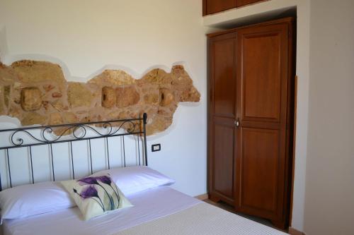 a bedroom with a bed and a wooden cabinet at HOTEL Cala Buguto in Custonaci