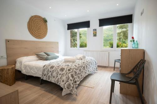1 dormitorio con 1 cama, 1 silla y ventanas en Apartament Rural La Colomina en Bernúy