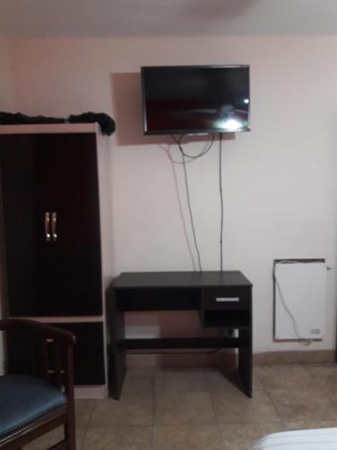 a room with a black dresser with a tv on a wall at Habitaciones BRISA in Salta