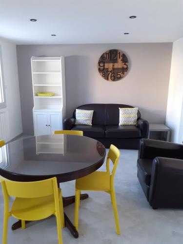 un salon avec une table et des chaises jaunes dans l'établissement Proche centre ville, à Mende