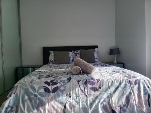 um quarto com uma cama com um edredão roxo e branco em Gerring Court with Free 1 Car Bay Parking em Perth