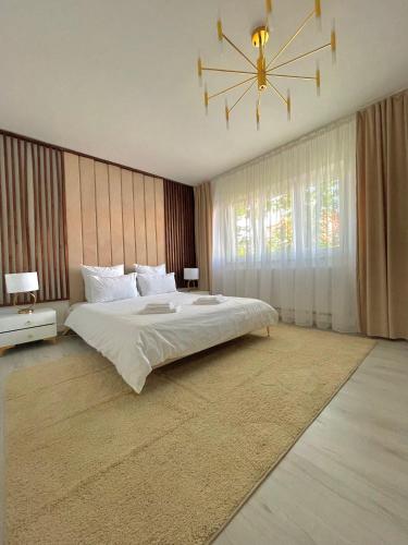 ein Schlafzimmer mit einem großen Bett und einem Kronleuchter in der Unterkunft Golden Valley Apartment in Sibiu