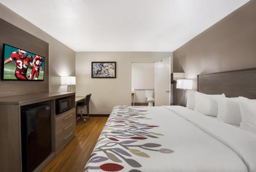 Una habitación de hotel con una cama y un televisor de pantalla plana. en Red Roof Inn & Suites Thomasville, en Thomasville
