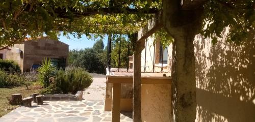 un bâtiment avec une véranda et un arbre dans l'établissement Casa Corte do Vale Alojamento Local, à Sertã