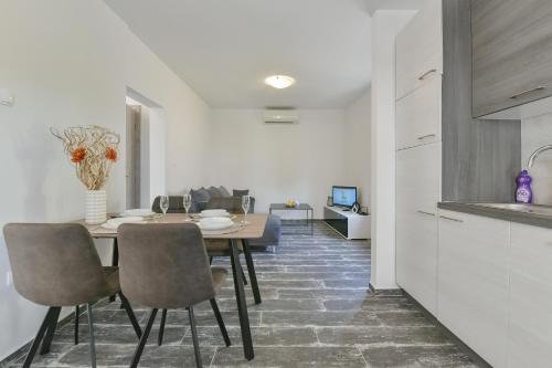 a kitchen and dining room with a table and chairs at Holiday homEna with a heated pool in Bibinje
