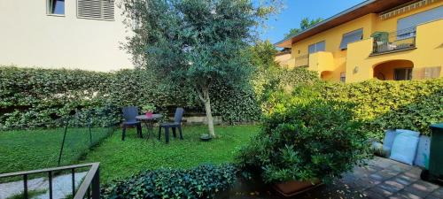 een kleine tuin met een tafel en stoelen naast een gebouw bij #10ilnumeroperfetto, independent entrance, private parking & garten in Morbio Inferiore