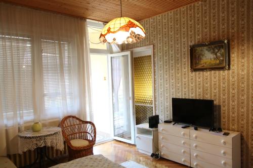 een woonkamer met een televisie op een dressoir bij Hajnalka Apartmanház in Gyula
