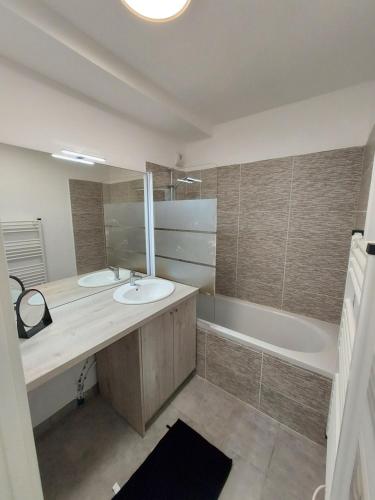 une salle de bain avec deux lavabos et une baignoire dans l'établissement COTE SOLEIL, à Mimizan