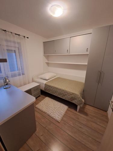 a small room with a bed and a desk at Apartment Mira in Šibenik