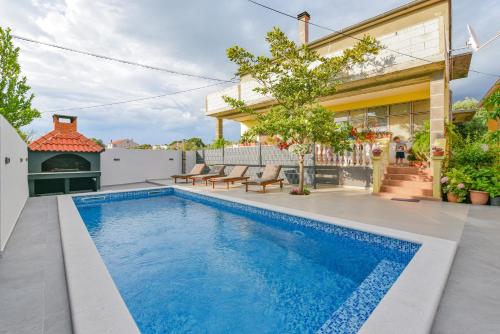 a swimming pool in the backyard of a house at Holiday homEna with a heated pool in Bibinje