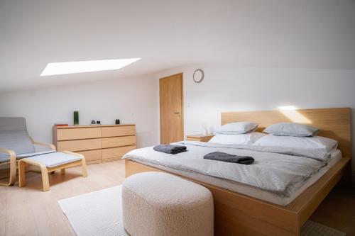um quarto com uma cama grande e uma cadeira em The Dante Villa Apartments em Praga