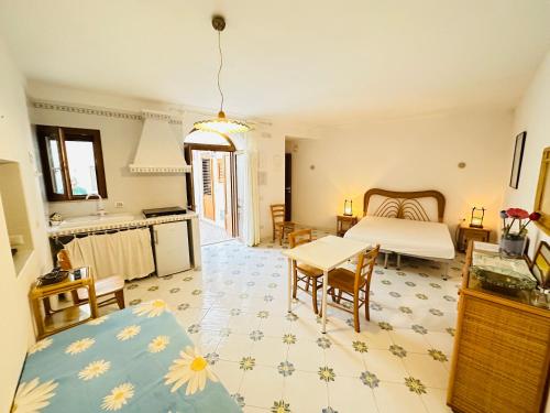 a bedroom with a bed and a table and a kitchen at La Donzella - Immobilevante in Ponza