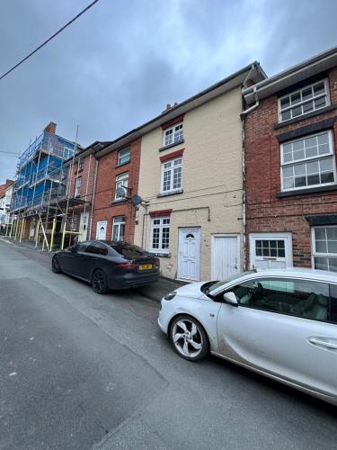 two cars parked on the side of a street at Newtown Townhouse in Newtown