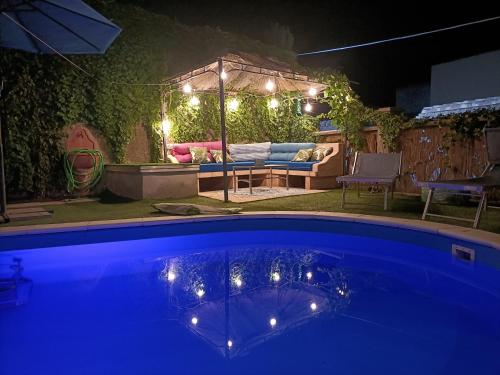 una piscina por la noche con una mesa y un sofá en Maison Belle Époque & suites, en Oristano