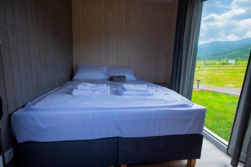 a bed in a room with a large window at Kwiatkowo - całoroczny kompleks z baliami i letnią plażą in Wünschelburg