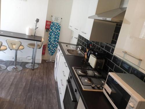 a kitchen with a stove and a counter top at Ensuite double-bed (R4) close to Burnley city centre in Burnley
