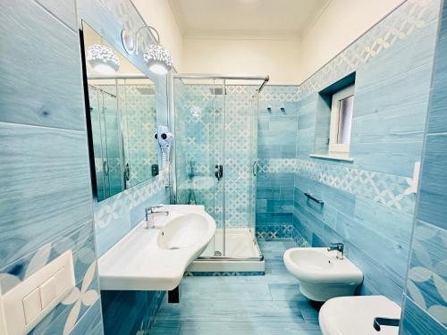 a blue bathroom with two sinks and a shower at Sky Ponza - Immobilevante in Ponza