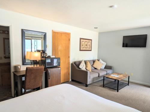 una camera d'albergo con letto, divano e tavolo di Western Riviera Lakeside Lodging a Grand Lake