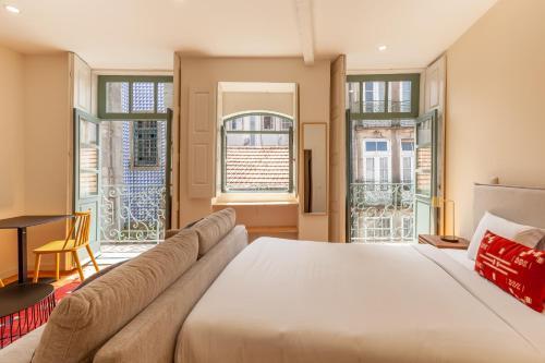 - une chambre avec un lit, un canapé et des fenêtres dans l'établissement Dasi House, à Porto