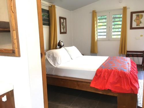 um quarto com uma cama branca e uma janela em TAHITI - Bungalow Honey Moon em Pirae