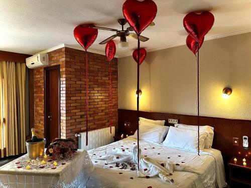 a bedroom with a bed with heart balloons on the ceiling at Natur Hotel - 700m da Rua Coberta in Gramado