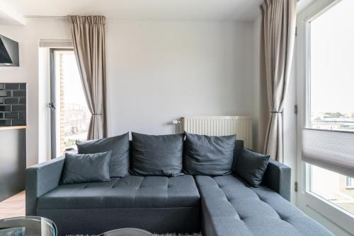 um sofá azul numa sala de estar com uma janela em Matti Beach Town House em Zandvoort
