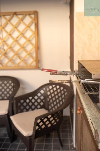 a kitchen with two chairs and a counter with an oven at Casa das Hortas in Vila Franca do Campo