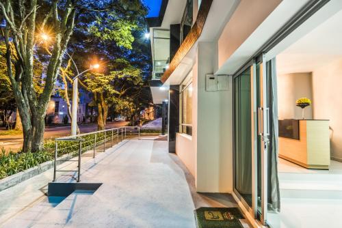 a walkway between two buildings at night with trees at Hotel Asturias Medellin in Medellín