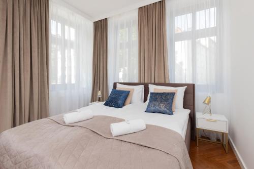 - une chambre avec un grand lit et des oreillers bleus dans l'établissement Stylish & Trendy Apartment Browar Gdański by Renters, à Gdańsk